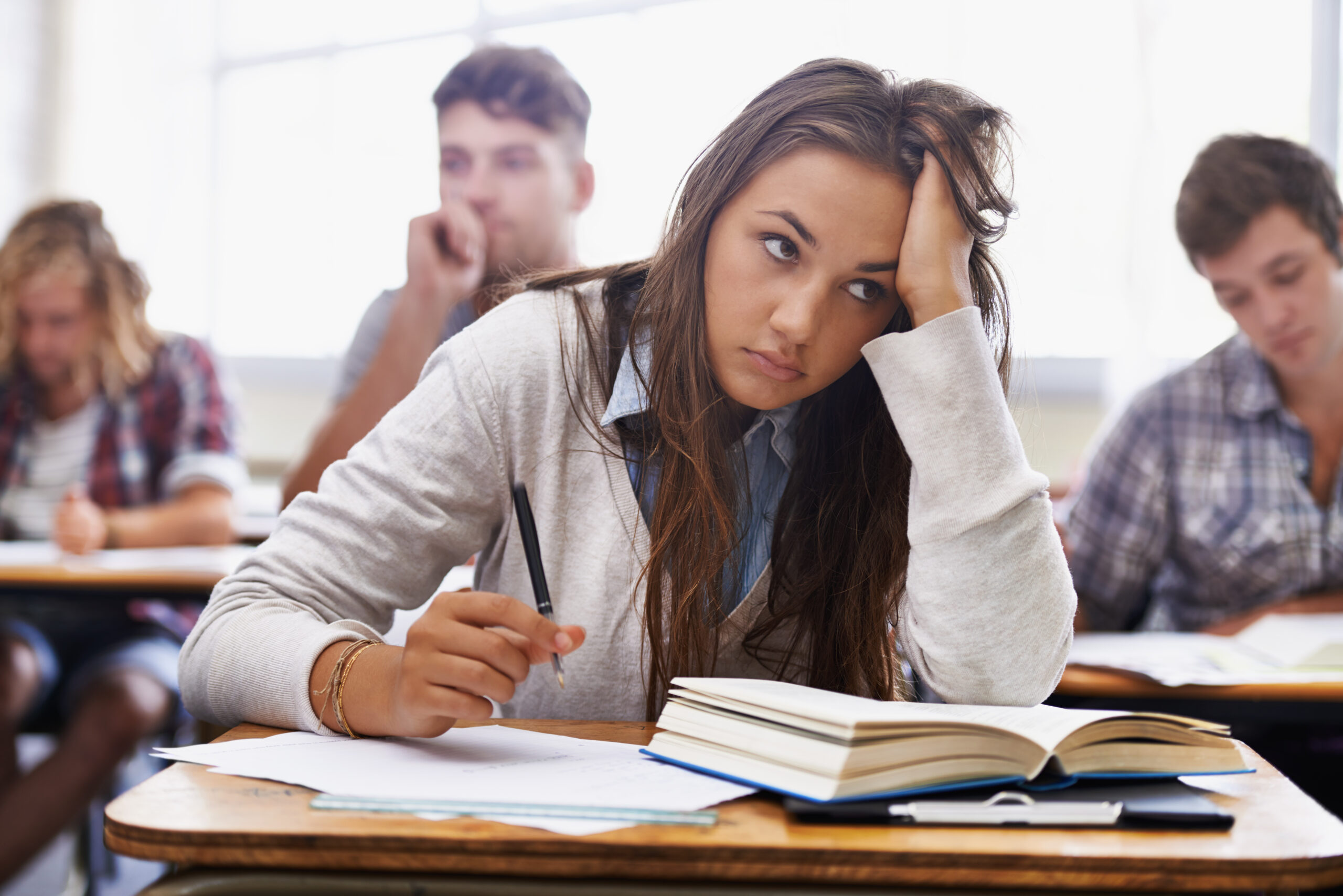 How will I handle this course load? How will I handle this course load. An overworked young student sitting with her head in her hands
